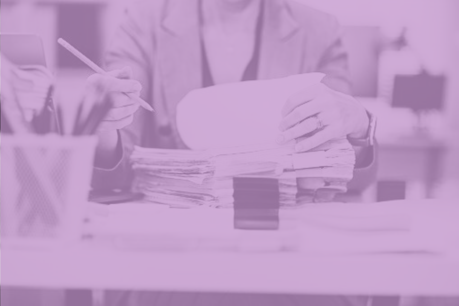 Persona revisando documentación y normativa en su escritorio, representando las obligaciones de cumplimiento de la directiva NIS2 para empresas